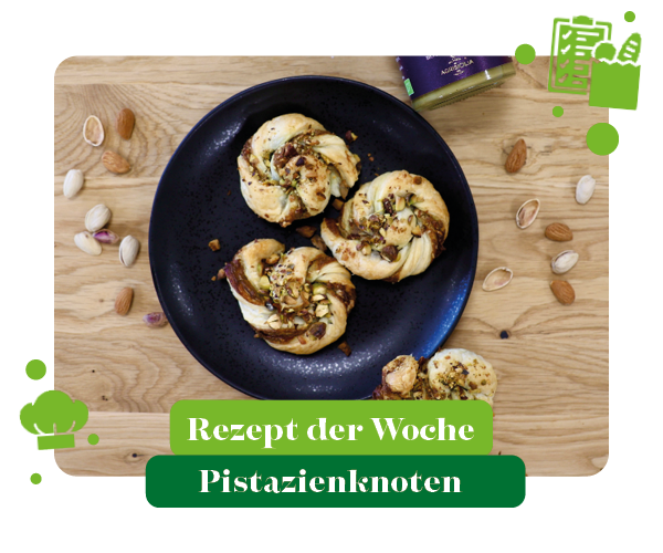 KI generiert: Ein schwarzer Teller mit Pistazienknoten, umgeben von Nüssen. Text: "Rezept der Woche Pistazienknoten".